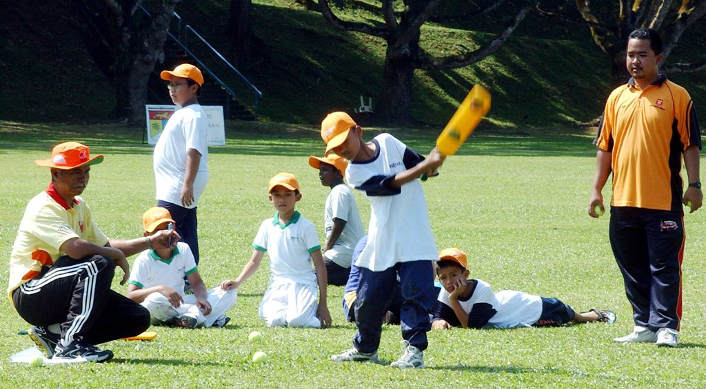 MOHD. HARIS ABU BAKER (kiri) meninjau cara pukulan seorang peserta klinik di Oval UKM.