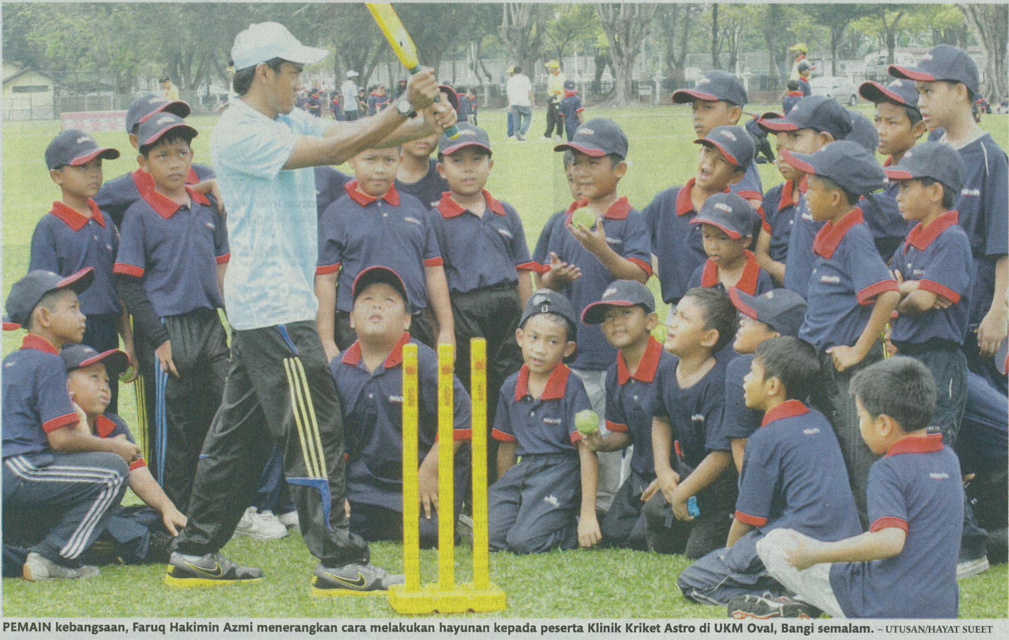 Pemain kebangsaan, Faruq Hakimin Azmi menerangkan cara melakukan hayunan kepada peserta klinik Kriket Astro di UKM Oval, Bangi semalam. - Utusan/Hayat Sueet